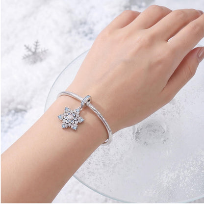 Blue Snowflake Dangle Charm worn on a charm bracelet