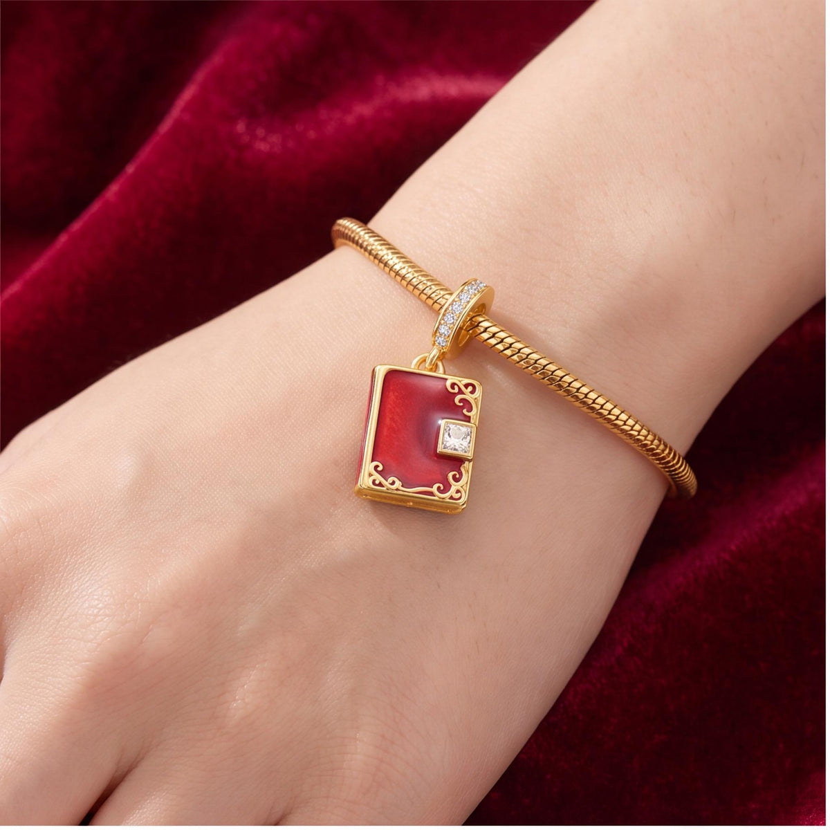 Red Book Dangle Charm worn on a charm bracelet