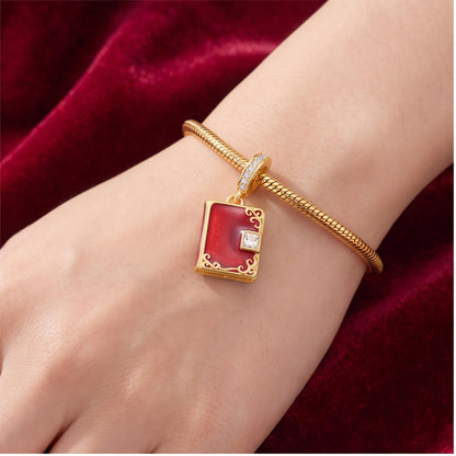 Red Book Dangle Charm worn on a charm bracelet