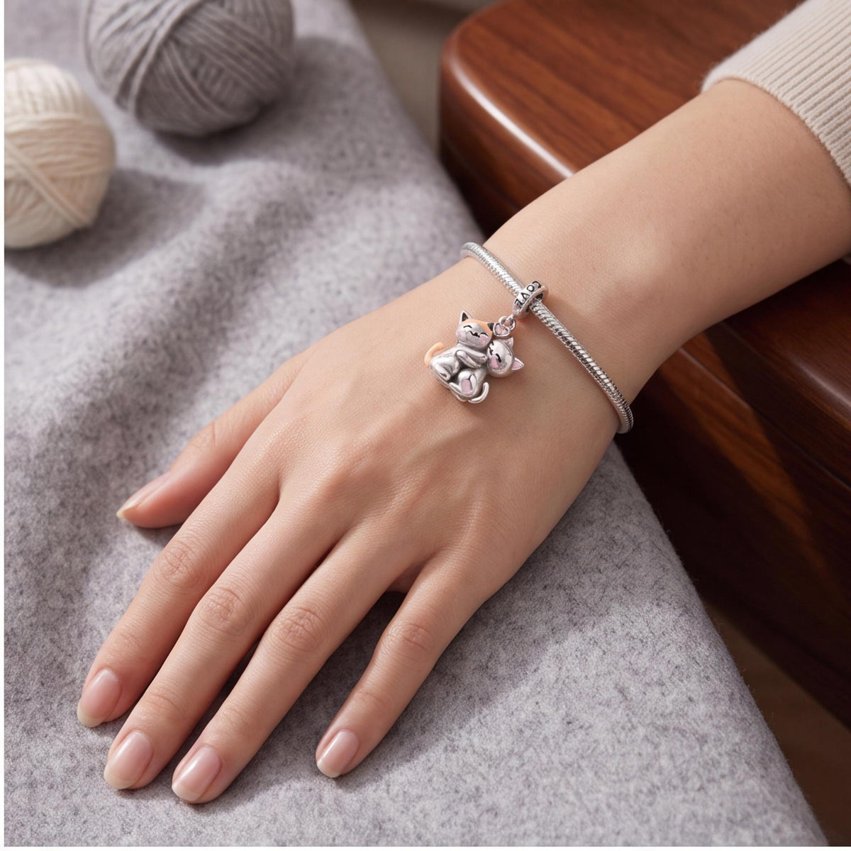 Hugging Cats Charm close-up on a bracelet