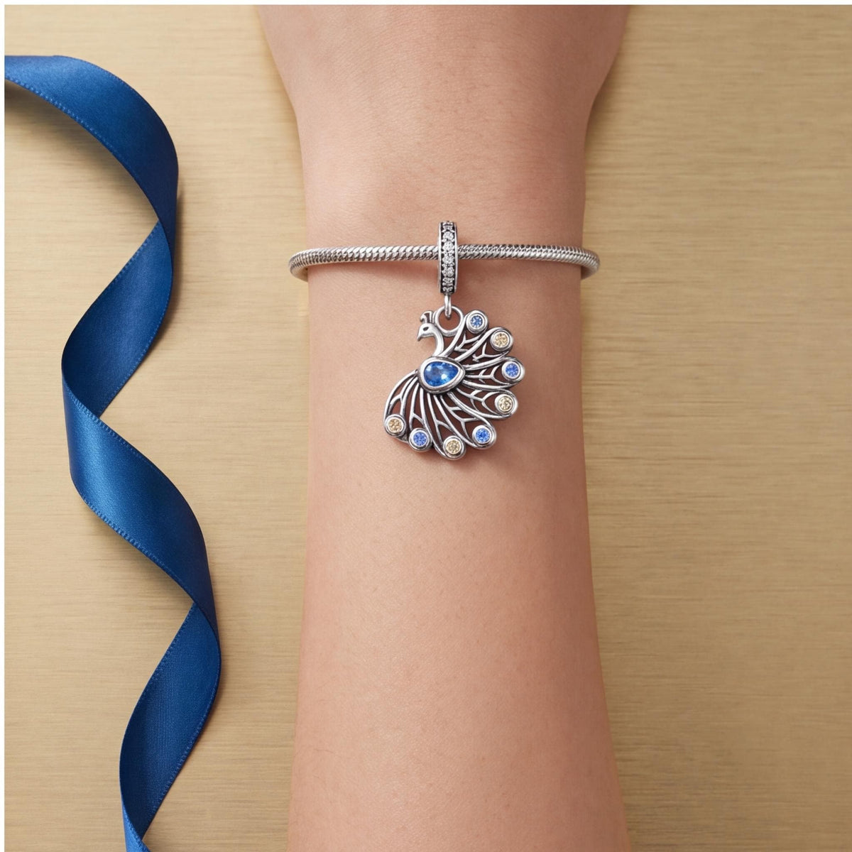 Peacock Dangle Charm worn on a charm bracelet